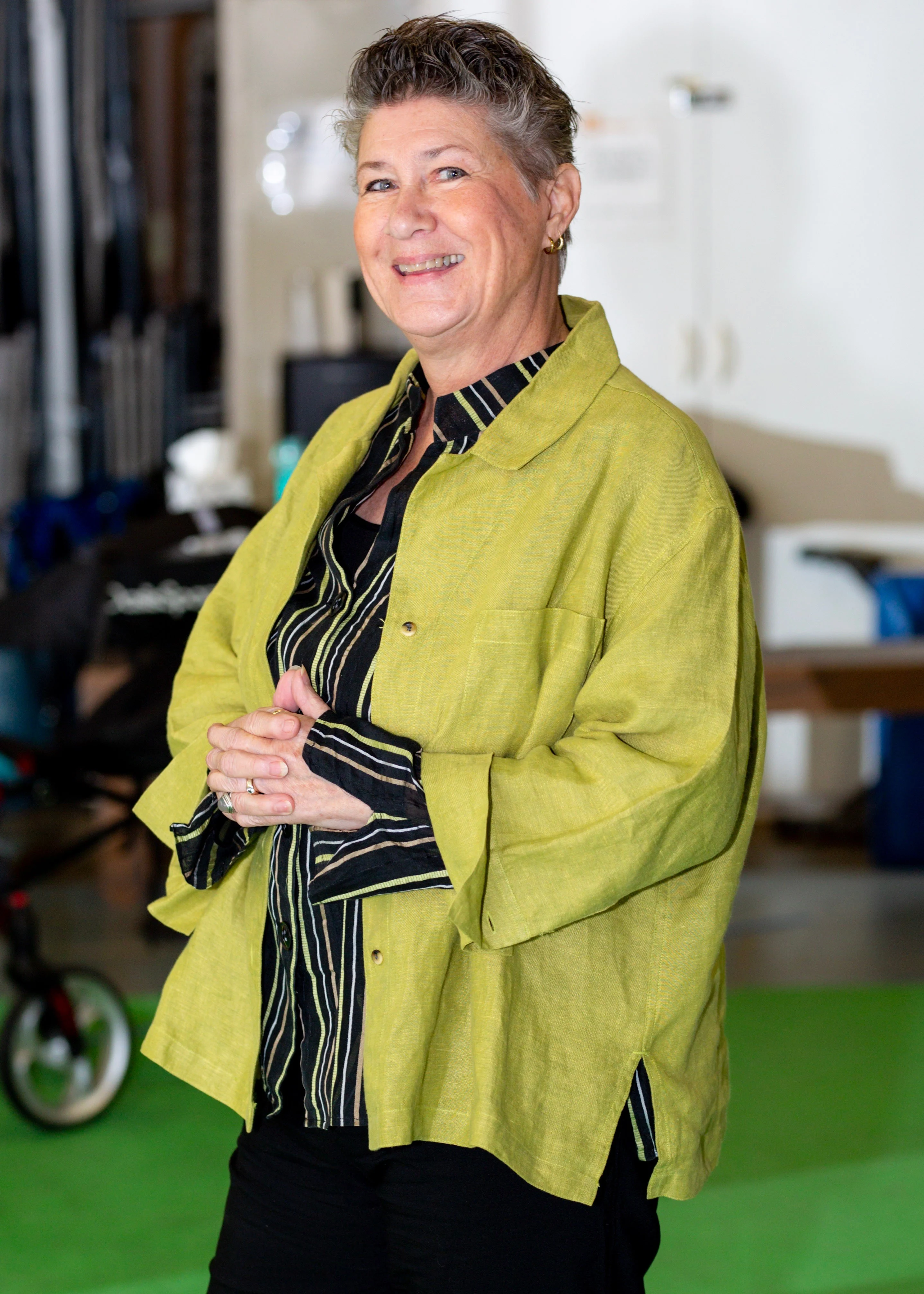 Cheryl King smiling in a chartreuse jacket in the studio
